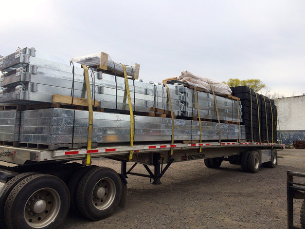 Truck carrying large steel channel dock on a trailer 
