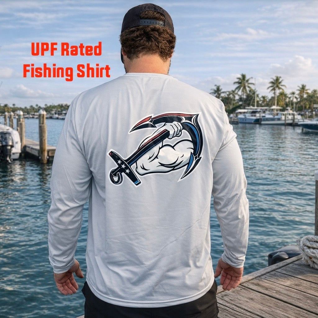 A man stands on a dock by the water wearing the American Muscle Docks AMD Cooling Performance UPF Tee (L/S) with an anchor and arm graphic on the back.