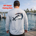 A man stands on a dock by the water wearing the American Muscle Docks AMD Cooling Performance UPF Tee (L/S) with an anchor and arm graphic on the back.