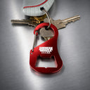 A Carabiner Bottle Cap Opener by American Muscle Docks is attached to a keyring with keys and a grey shoe on a metallic surface.