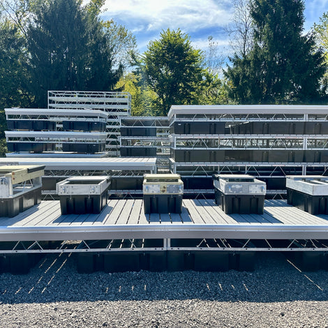Row of Dock types on display sitting on a steel truss composite dock with other finished docks stacked in the background
