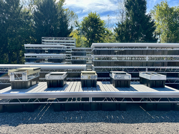 Row of Dock types on display sitting on a steel truss composite dock with other finished docks stacked in the background
