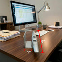 The American Muscle Docks Dock Cleat Business Card Holder, a silver metal piece measuring 6 inches tall by 1 inch wide, sits on a desk next to a computer monitor.