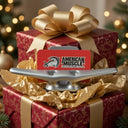 A wrapped gift box with a gold bow contains the American Muscle Docks Dock Cleat Business Card Holder and a brand card, displayed in a festive holiday setting—the perfect gift for boaters this season.