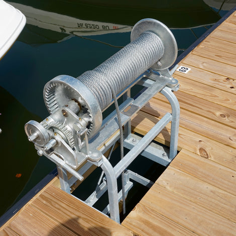 Boat lift mechanism on a wooden dock with boats in the background built by American Muscle Docks