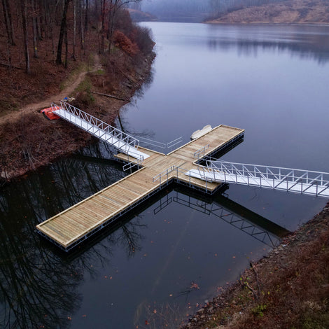 Wooden dock extending into a lake with two gangways attached to hiking trail