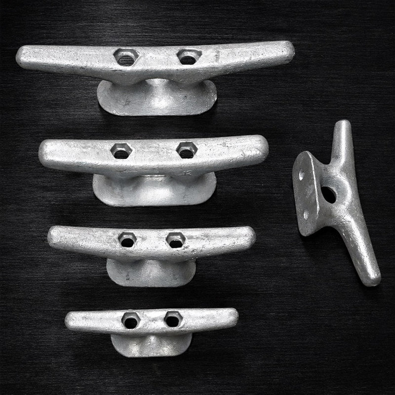 Four American Muscle Docks & Fabrication Cleat - Steel Ship dock cleats are vertically aligned on a dark surface, with a fifth cleat to the right, oriented differently.