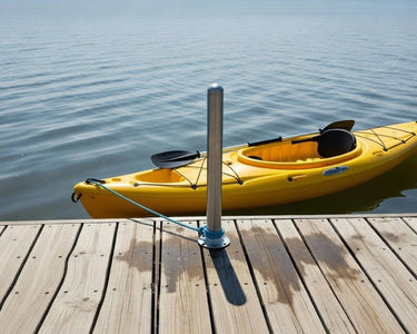 Yellow kayak with paddles on a wooden dock by calm water teathered to a Helping Hand support post by American Muscle Docks