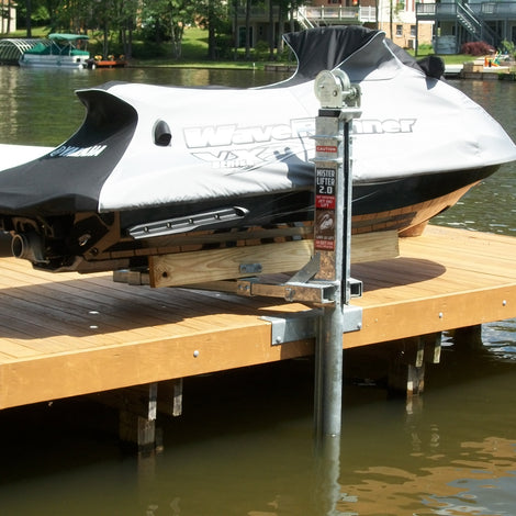 A covered jet ski is parked on a wooden dock above the water, supported by a metal boat lift system.