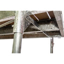 Close-up view of the underside of a metal table or workbench, featuring metal legs, support beams, and a slatted surface with an American Muscle Docks & Fabrication Stationary Dock Bracket for extra support.