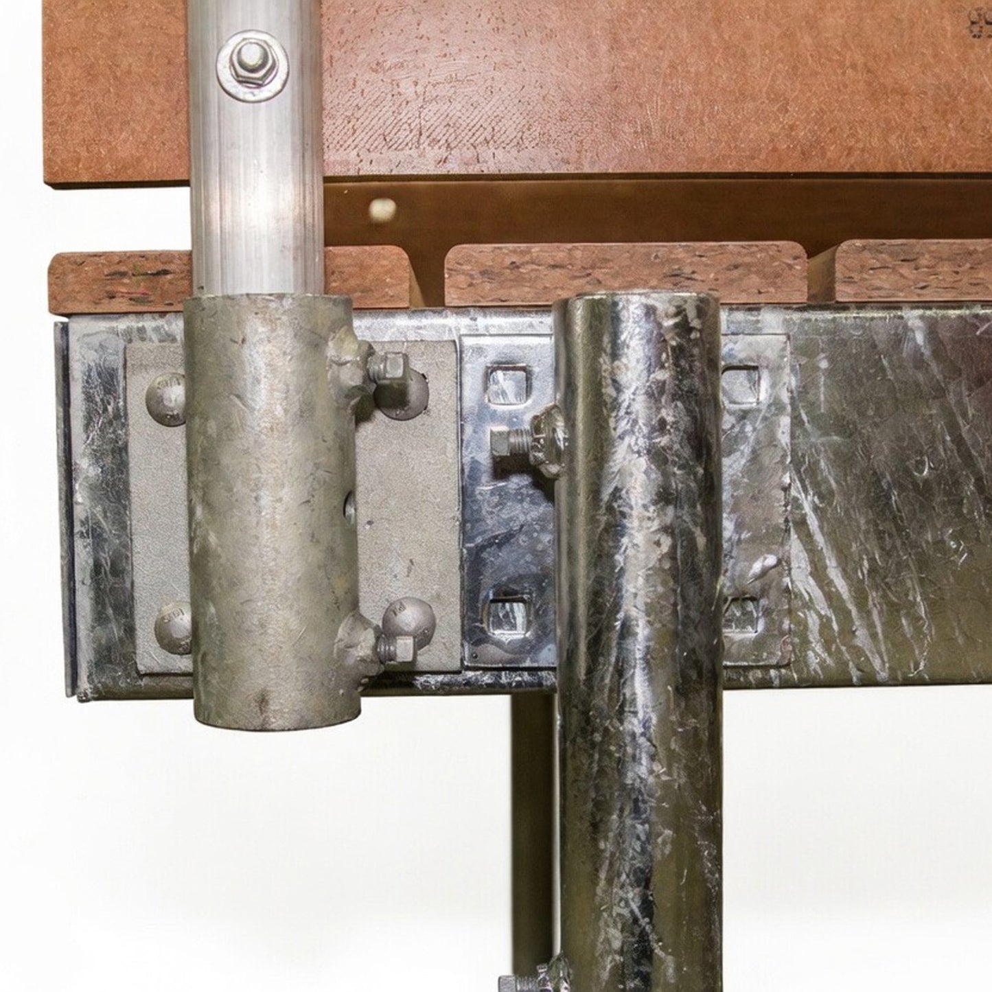 Close-up of American Muscle Docks & Fabrication's Stationary Dock Bracket, connected with bolts to metal pipes and attached to a wooden structure in the background.